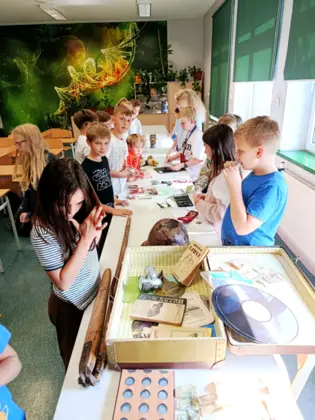 Uczniowie na lekcji historii, oglądają rodzinne pamiątki